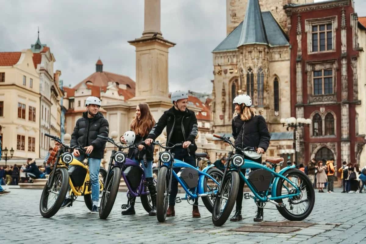 Čtyři jezdci s barevnými café-racer e-koly na Staroměstském náměstí